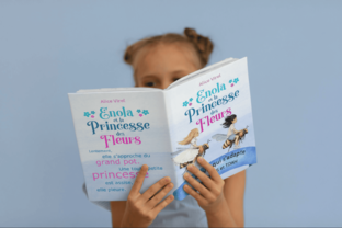 Enfant qui lit le livre Enola et la Princesse des Fleurs
