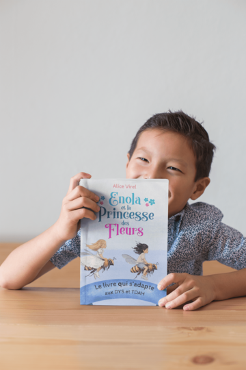 Enfant avec le livre Enola et la Princesse des Fleurs